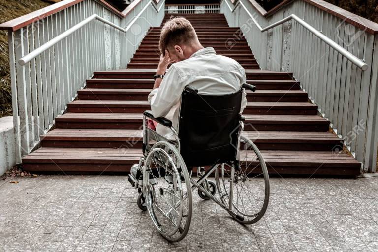 Person in wheelchair in front of stairs